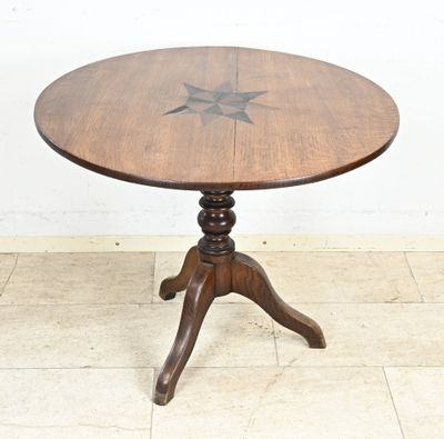 une table en bois ornée d'une étoile, posée sur un sol carrelé