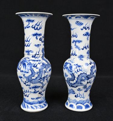 deux vases bleus et blancs ornés de motifs de dragons sur fond noir