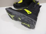 pair of black and yellow snow boots sitting on top of a white counter
