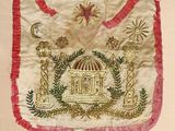 an image of a white and red embroidered bag with a birdcage on it