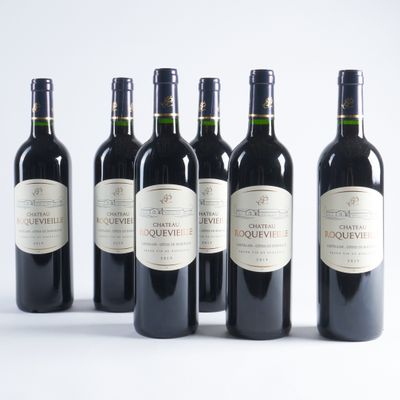 six bouteilles de vin sont alignées sur une surface blanche