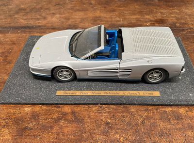 une maquette de voiture de sport argentée posée sur une table