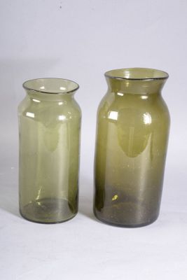 two glass vases sitting next to each other on a white surface