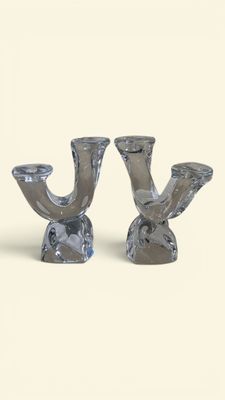 deux chandeliers en argent posés sur une surface blanche