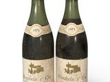 deux bouteilles de vin posées l'une à côté de l'autre sur une surface blanche