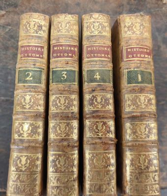 quatre vieux livres posés sur une table en bois