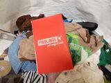 a pile of clothes on a bed with a red book