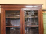 a cabinet with a glass door that is in a room