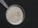 an overhead view of a pan with a handle on a black surface