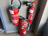 two fire extinguisors sitting next to each other on the floor
