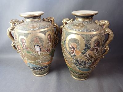 deux vases ornés de portraits, posés sur une table