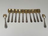 six spoons and a fork are lined up on a white surface
