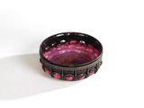 a small purple bowl sitting on a white surface