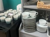 a lot of plates and cups on the counter