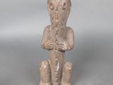 une petite statue représentant un homme assis sur une table