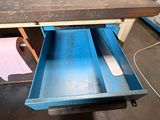 a blue drawer with a knife in it in a workshop