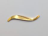 a gold plated hair clip on a white surface