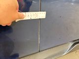 a hand that is holding a sticker on a car door