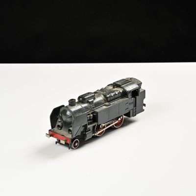 un petit train sur une surface blanche avec un fond noir