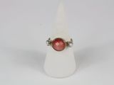 a close up of a ring with a red stone on it