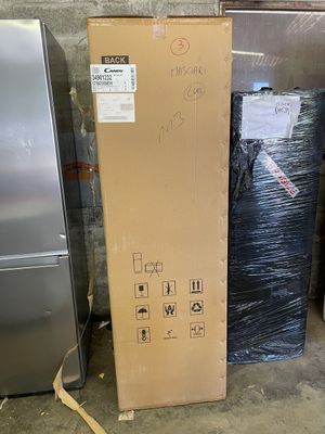 a large box sitting next to a refrigerator in a warehouse