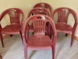 several red plastic chairs are lined up in a row in the corner of a room