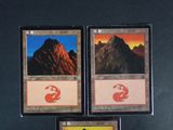 three cards with different designs are displayed on a black surface