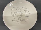 a white plate with a drawing of a man ' s face on it