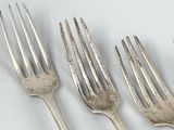 four forks that are sitting next to each other on a table