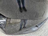 a reflection of a person standing on the hood of a car
