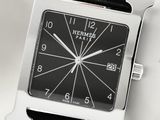 a black and silver square watch on a black leather strap