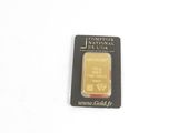 gros plan d'un lingot d'or sur une surface blanche