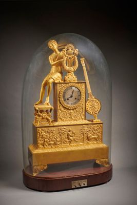 une horloge en or sous un dôme de verre sur une table