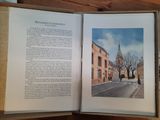 an open book with a picture of a church in the background