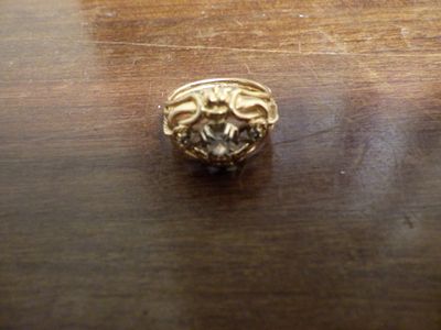 une bague en or posée sur une table en bois, sertie d'un diamant