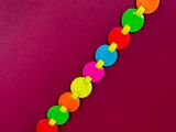 a close up of a colorful bracelet on a purple surface