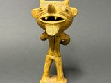 an image of a yellow figurine of a demon with horns