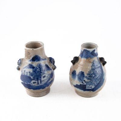 paire de vases bleus et blancs posés sur une surface blanche
