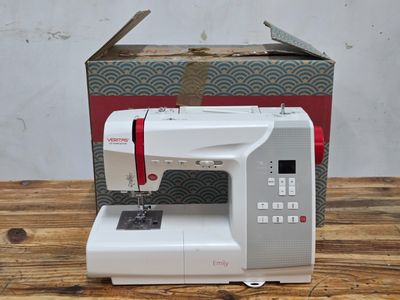 the sewing machine is sitting on a wooden table next to a box