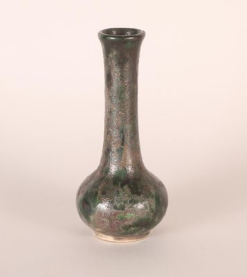 a green vase that is sitting on a white surface