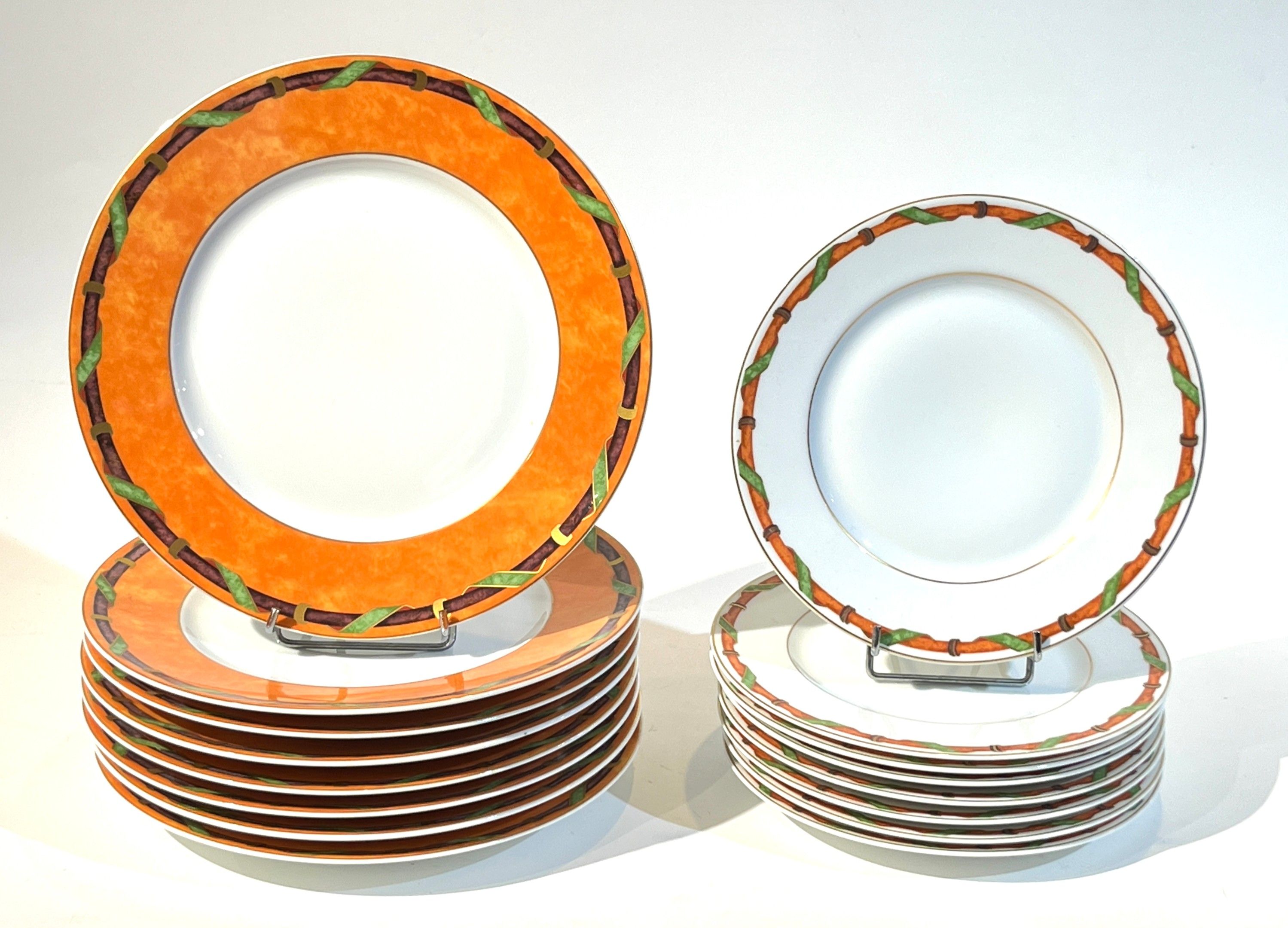 RAYNAUD et Cie à Limoges. Suite de 8 assiettes de présentation en porcelaine l'aile à décor de frise de ruban sur fon...