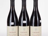 three bottles of red wine sitting on top of a white table