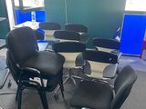 a room with several chairs and a table with a laptop on it