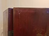 a red suitcase sitting on top of a wooden table