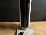 un ventilateur posé sur une table à côté d'une télécommande