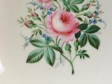 a white plate with pink flowers and green leaves