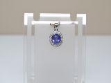 an image of a blue sapphire and diamond pendant on a clear display case