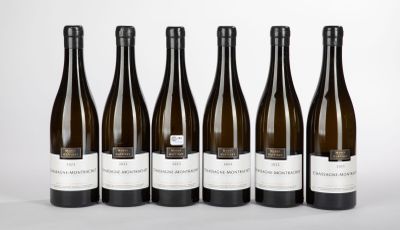 six bottles of wine are lined up in a row on a white surface