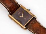 a watch that is sitting on top of a brown strap