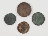 a group of four bronze coins sitting on top of a white surface
